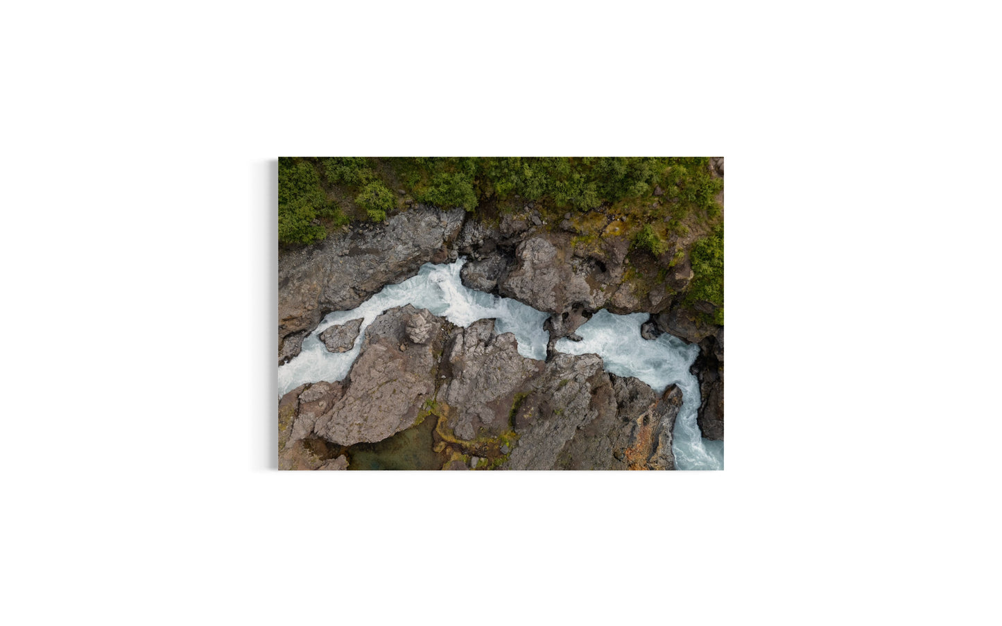landskabsbillede af det unikke lavavandfald "Hraunfossar" på Island. Dronebillede af landskab, natur og arkitektur trykt som plakat eller på lærred til hjemmet.